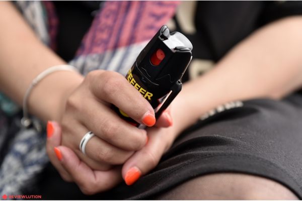 woman holding pepper spray in hands 