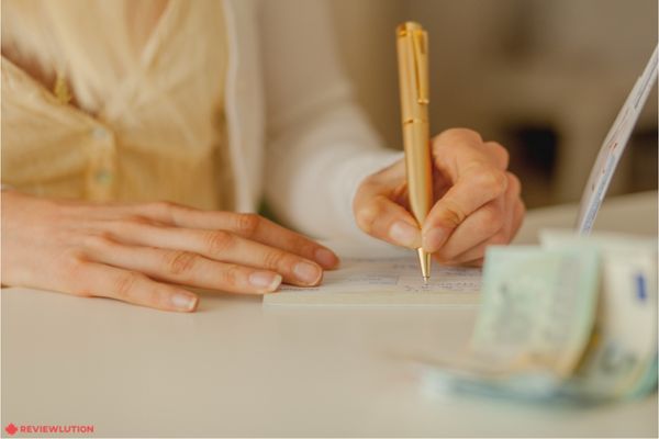 A woman writing a cheque to herself due to Easy money transfer between accounts