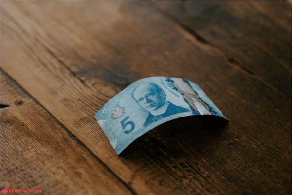 canadian 5 dollar bill on a wooden table