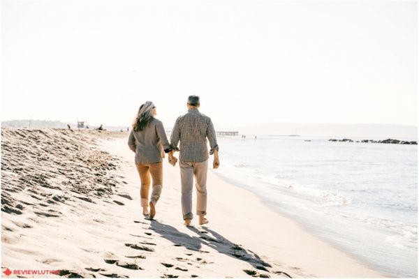 a couple walking on a beach barefoot