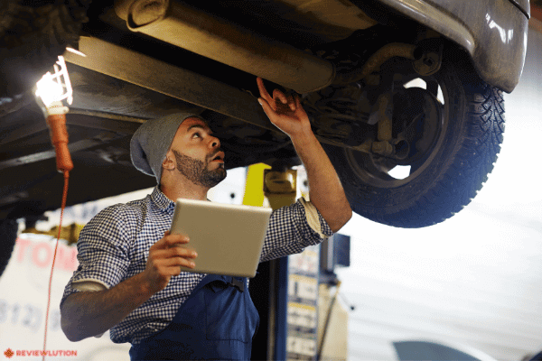 a mechanic inspecting under a car