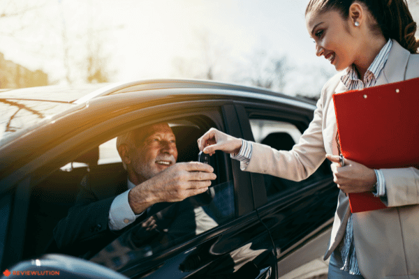 a car saleswoman selling a car to an older man